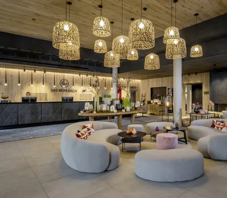 große gemütliche Lobby im Das Mühlbach mit runden Sofaecken und Blick auf die Rezeption