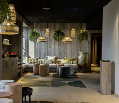 Eingang zum Spabereich im Das Mühlbach mit bunt gemusterten Kissen, Korblampen und Hängepflanzen