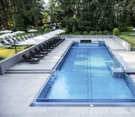 Ganzjährig beheizter Infinity-Außenpool im Hotel der Sonnenhof mit vielen Liegemöglichkeiten im Hotelpark