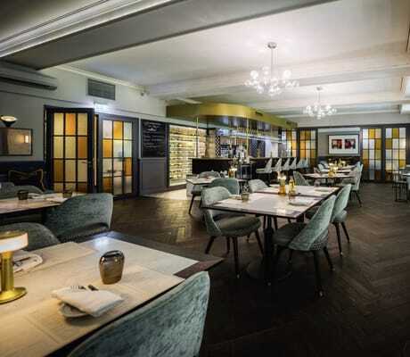 Blick in das französische Restaurant Petit Plaisir mit eingedeckten Tischen im Wellnesshotel Der Sonnenhof