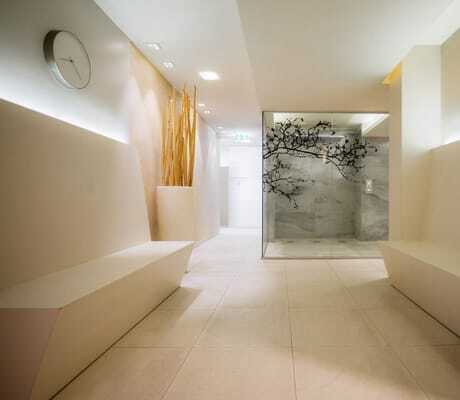Saunabereich im Wellnesshotel Der Sonnenhof in heller Farbe mit Dusche und Sitzbänken
