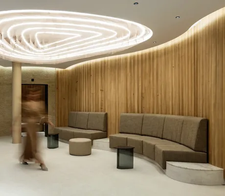 Spebereich innen im Huus Quell mit reduziertem Innendesign und kreisförmiger Lichtinstallation an der Decke