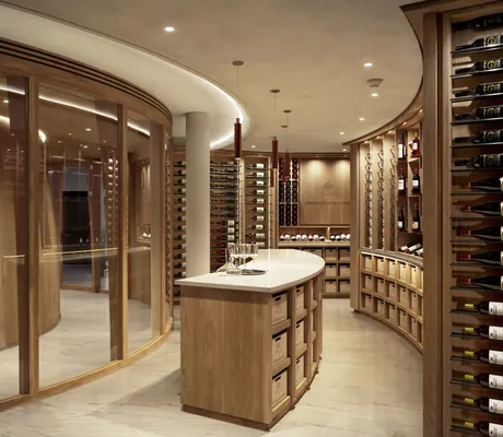 rund angelegter Weinkeller im Huus Quell mit Theke und Rotweinflaschen