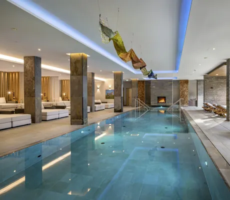 Indoorpool mit Kamin und goldenem Ornament an der Decke im Klosterhof