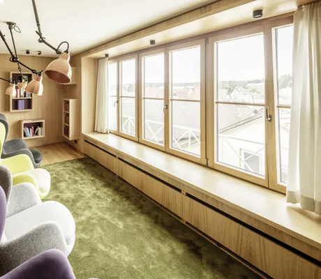 Bibliothek in der Kuroase im Kloster mit bunten Ohrensesseln und Blick über die Dächer