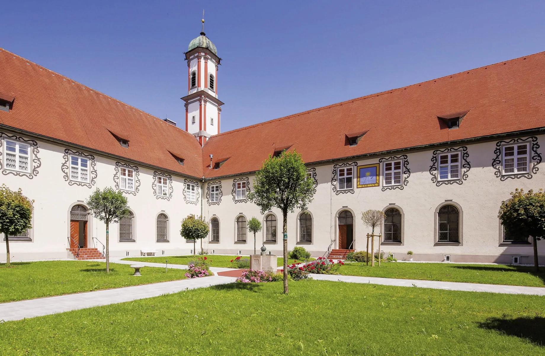 Klostergarten in der Kuroase im Kloster mit Blumenrabatten und kleinen Bäumen