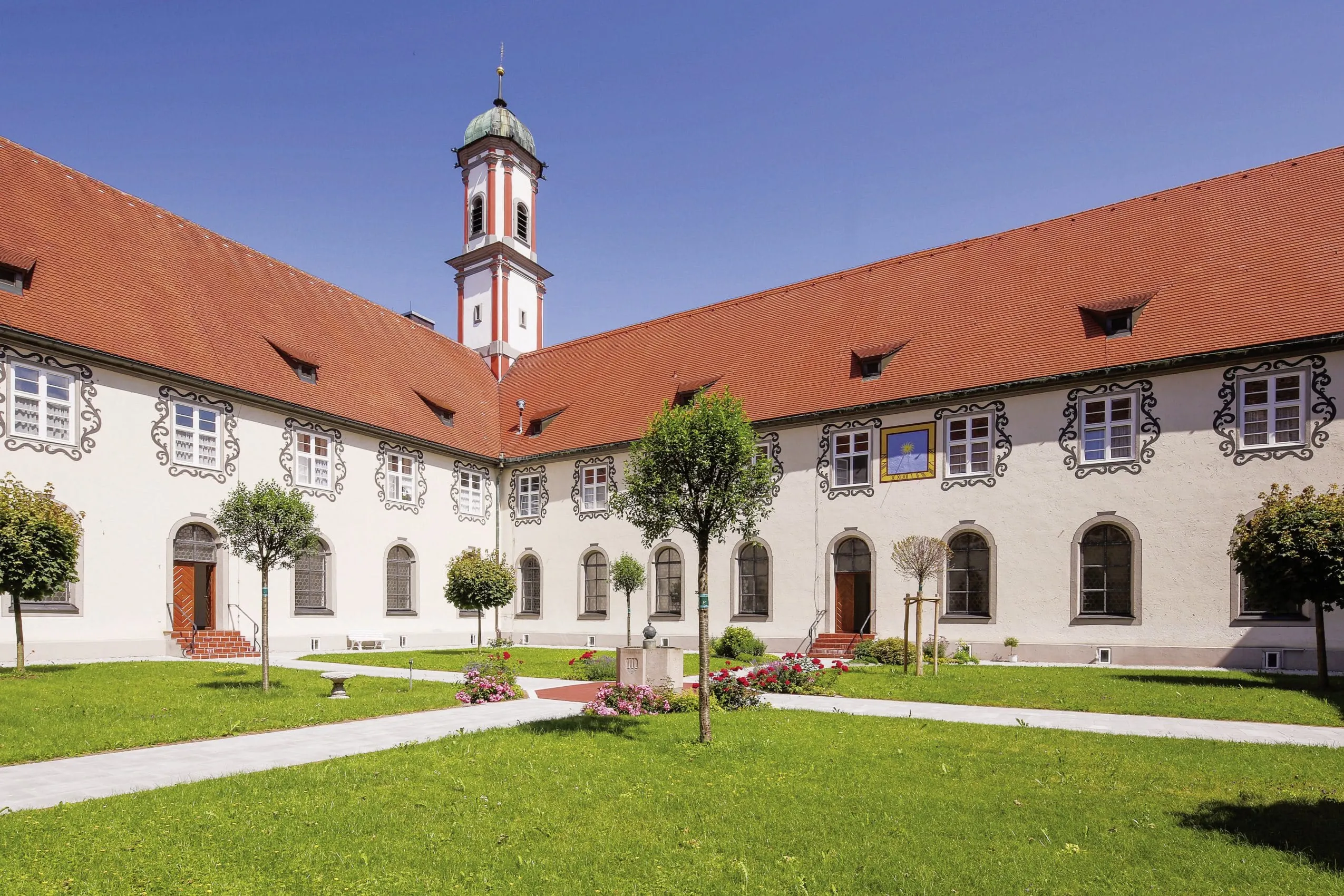 Klostergarten in der Kuroase im Kloster mit Blumenrabatten und kleinen Bäumen