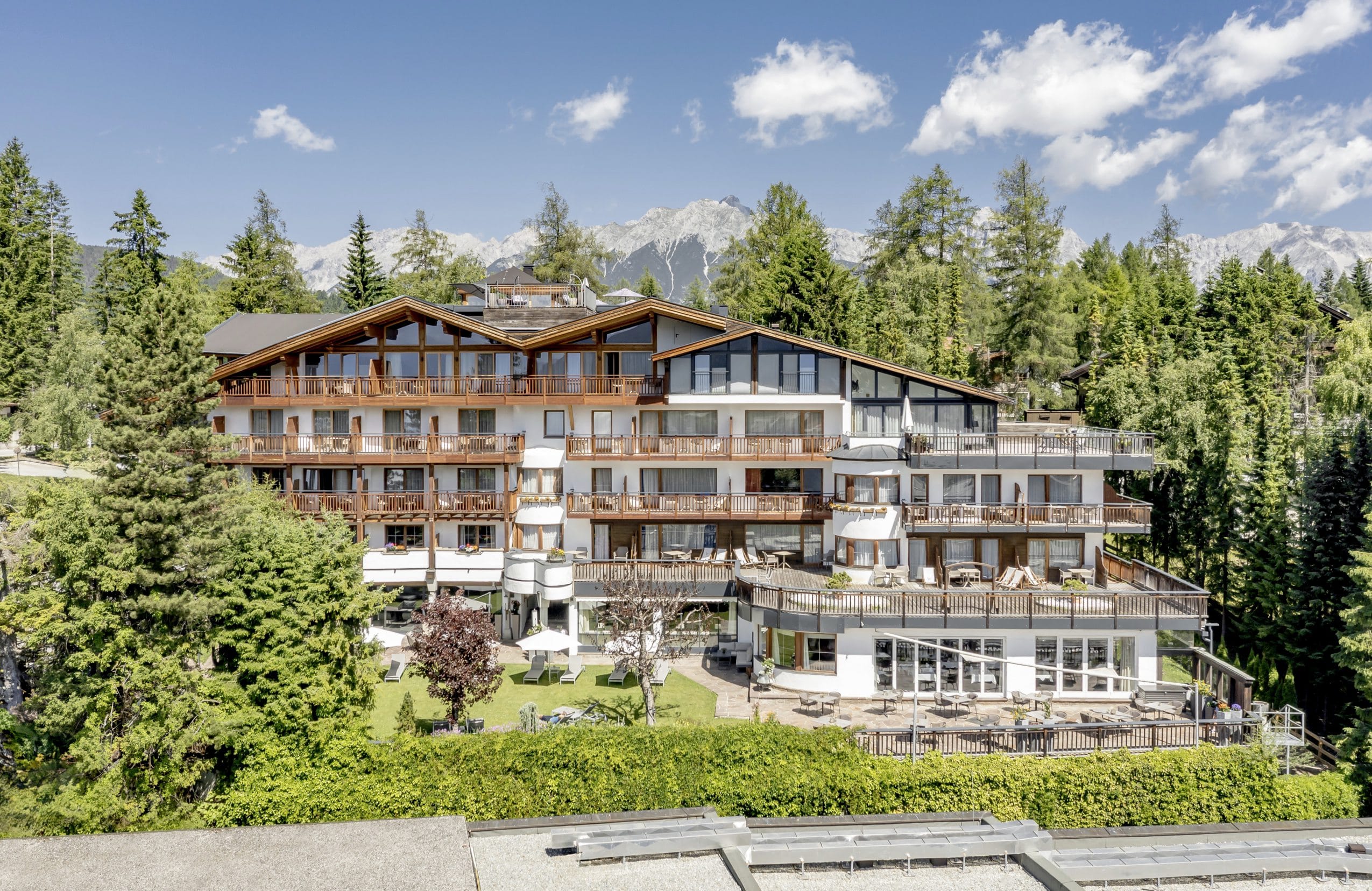 Außenansicht des Lärchenhof mit Holzbalkonen und Blick ins Karwendelgebirge
