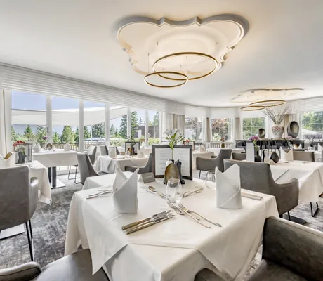 gedeckte Tische im Restaurant des Lärchenhof mit runden Lampen und Stuckelementen