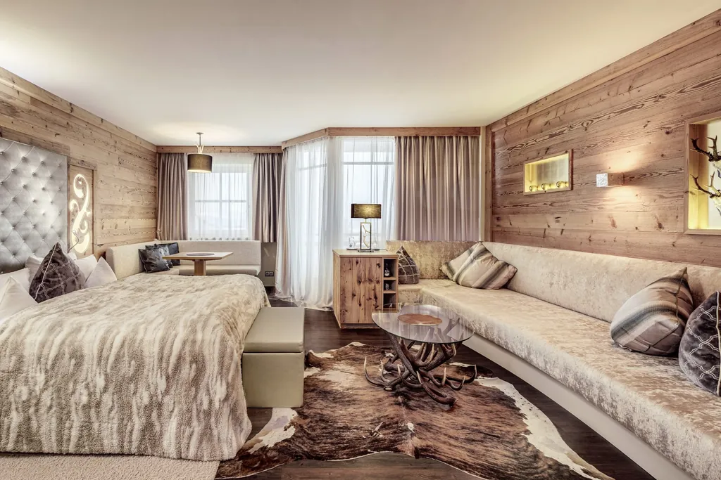 luxuriöse holzvertäfelte Suite im Landromantikhotel Oswald mit Kuhfellteppich