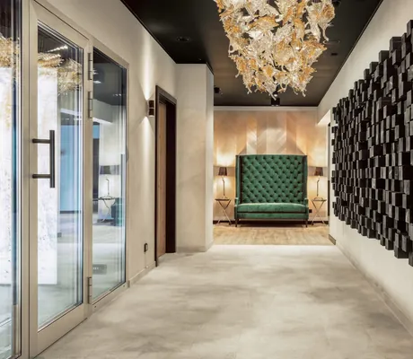 Gang im Landromantikhotel Oswald mit schwarzen Würfeln an der Wand und grünem Samtsofa