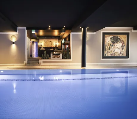 Indoorpool im Landromantikhotel Oswald mit Klimt-Bild und Blick auf Feuerstelle