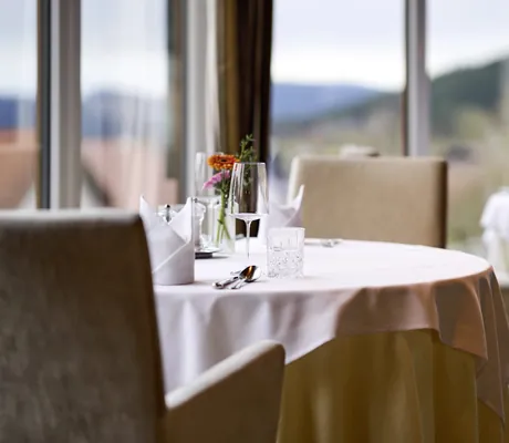 gedeckter runder Tisch im Restaurant des Landromantikhotel Oswald am Fenster