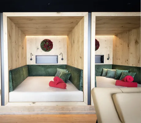 Liegekojen im Landromantikhotel Oswald mit grünen Polstern und roten Decken