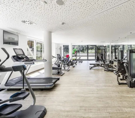Fitnessraum im Lürzerhof mit weißer gelöcherter Decke und Panoramafenster