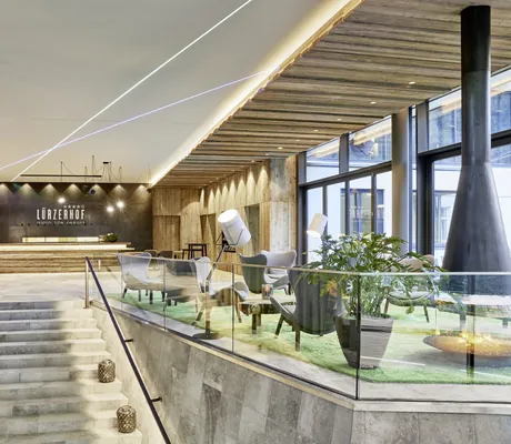 Treppe zur Rezeption im Lürzerhof mit Hängekamin und Ohrensesseln