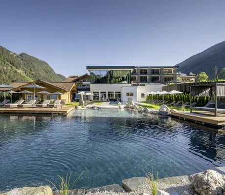 Blick über den Naturbadeteich auf die Fassade des Lürzerhof