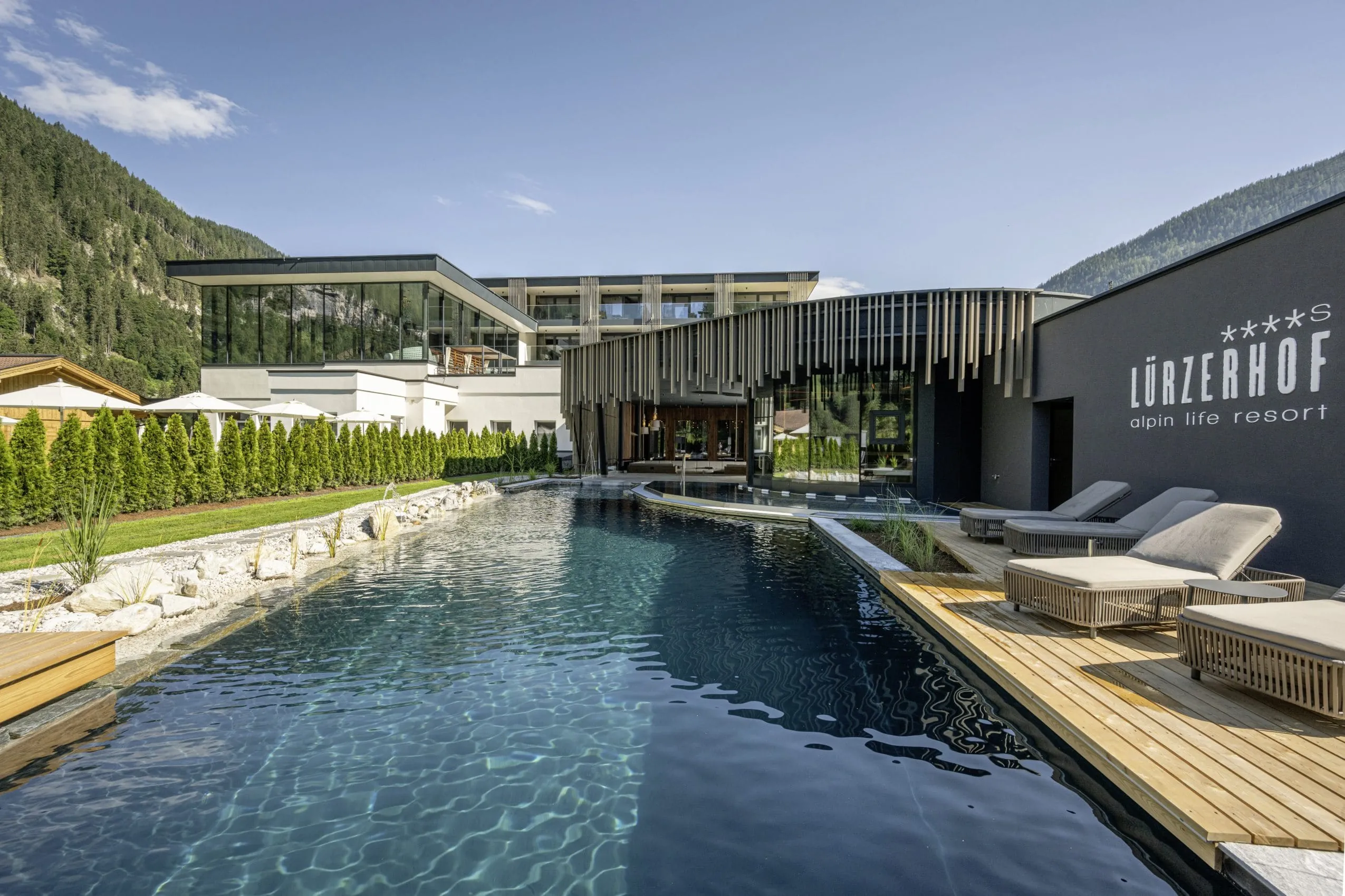 Outdoorpool im Lürzerhof mit Blick auf das große Spafenster mit hängenden Röhren