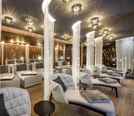 Ruhebereich im Lürzerhof mit grauen Liegen und beleuchteten Vorhang-Trennwänden