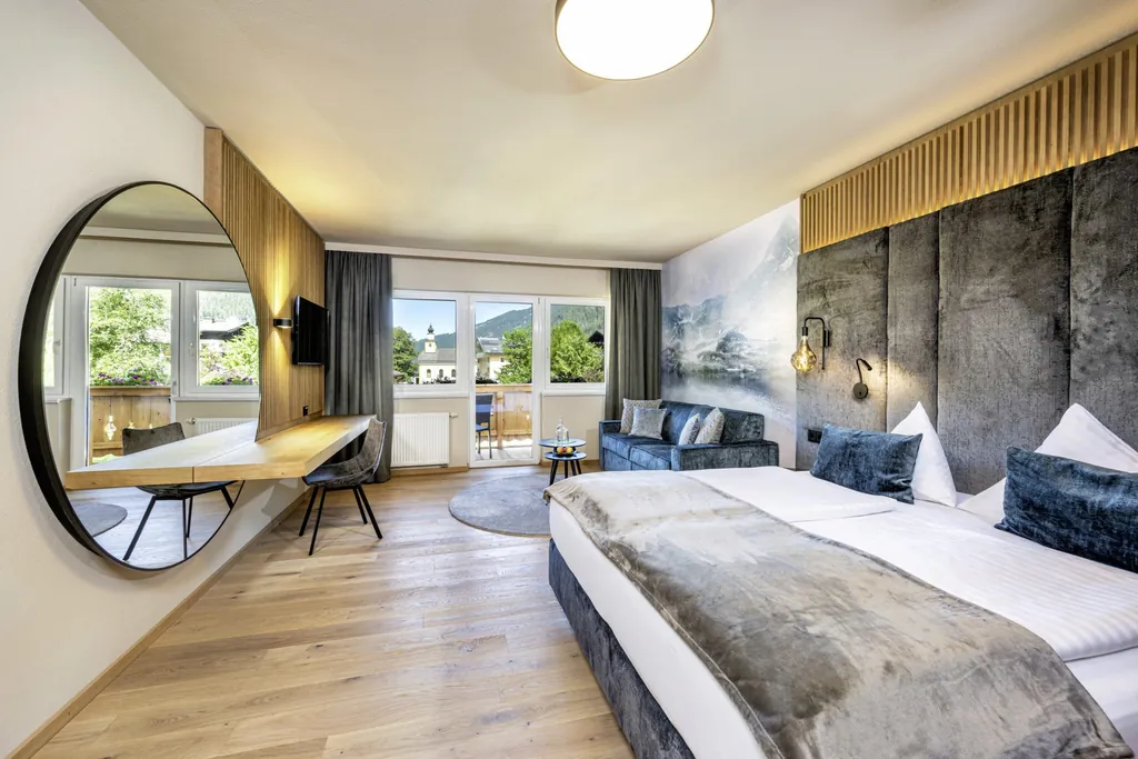 Doppelzimmer im Lürzerhof mit großem runden Spiegel und grauem Bettkopf