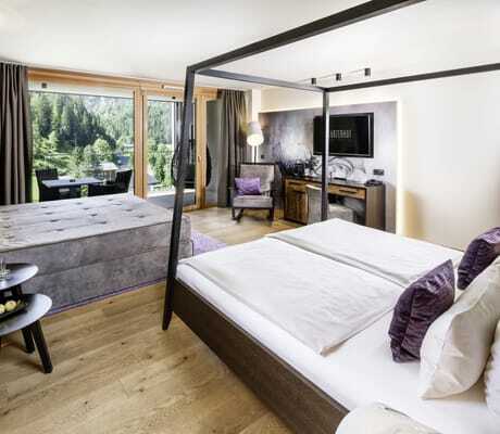 Zimmer im Lürzerhof mit schwarzem Himmelbett und grauem Doppelsofa