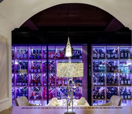 festlich eingedeckter Tisch vor Weinregal am Abend im Mooshof