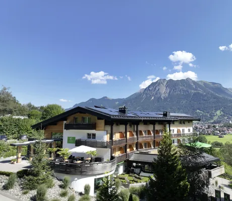 Außenansicht Naturhotel Waldesruhe mit Terrasse und Blick auf die Berge