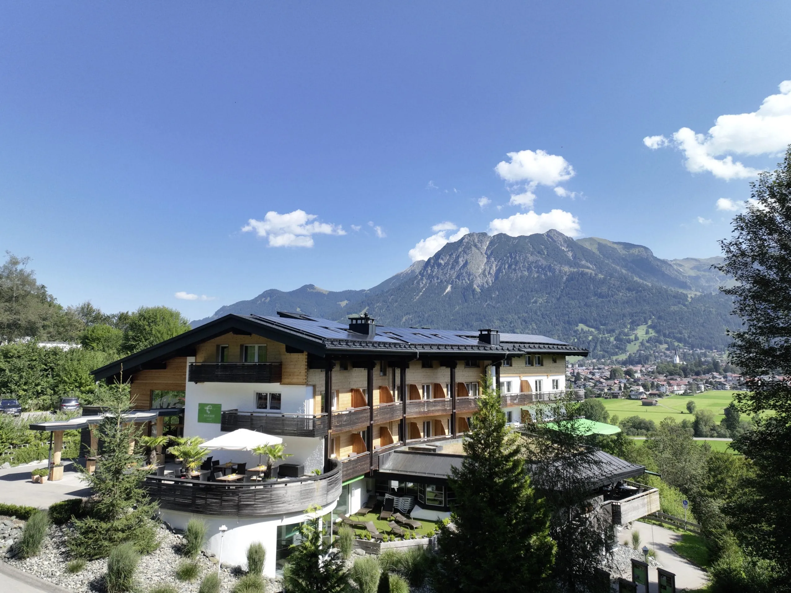 Außenansicht Naturhotel Waldesruhe mit Terrasse und Blick auf die Berge