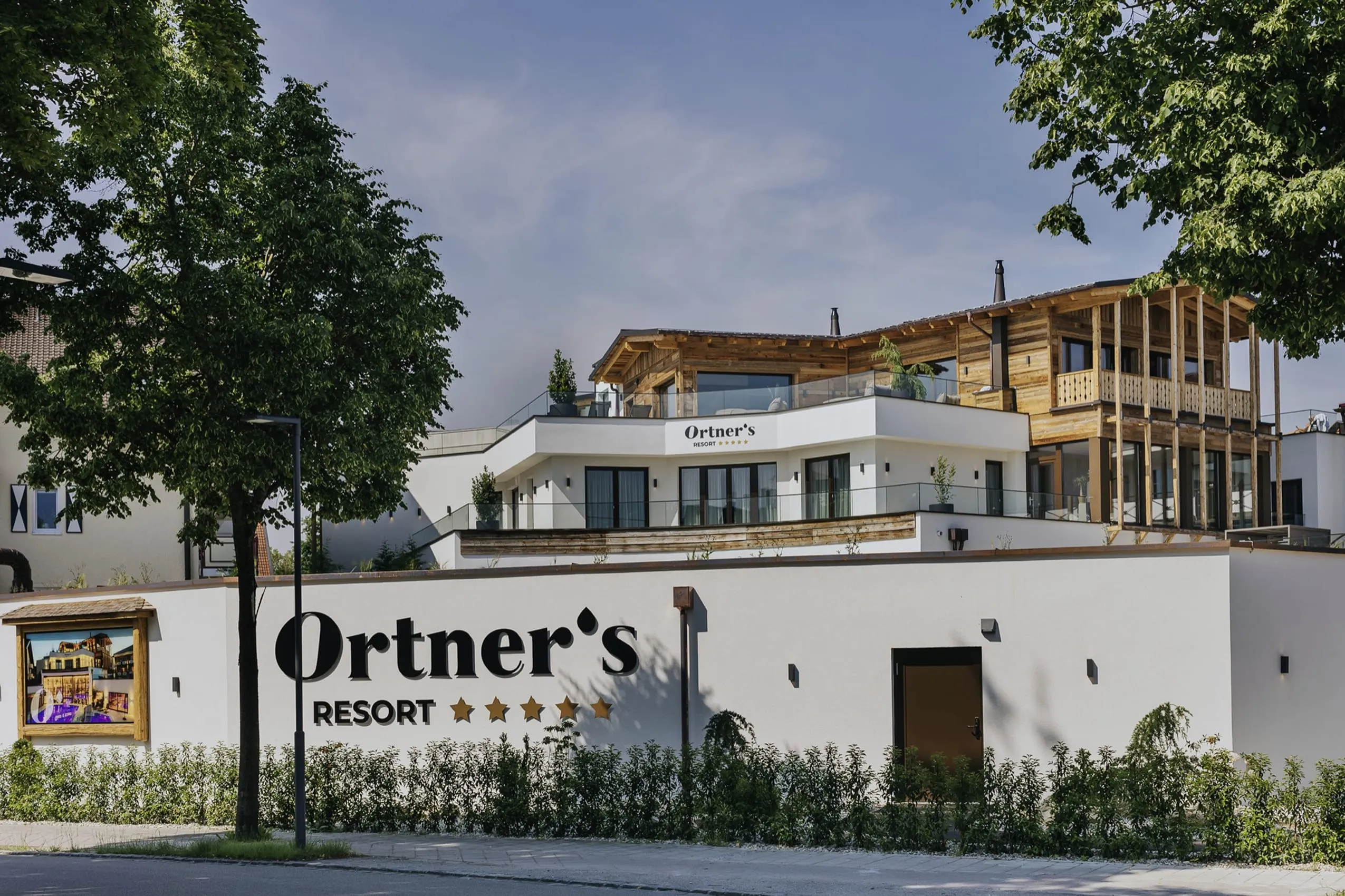 Fassade Ortner's Resort mit Schriftzug und Blick auf großen Holzanbau