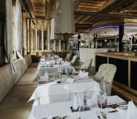 eingedeckte Tische im Restaurant des Ortner's Resort mit großen tulpenförmigen Lampen