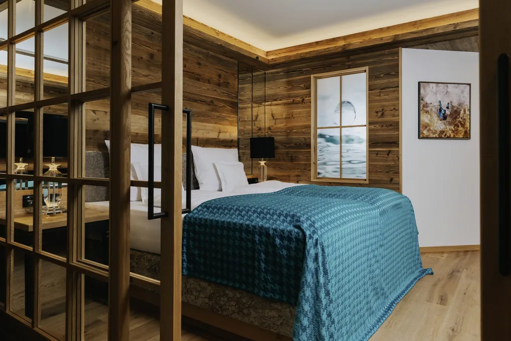 holzgetäfeltes Zimmer im Ortner's Resort mit türkisem Bettüberwurf
