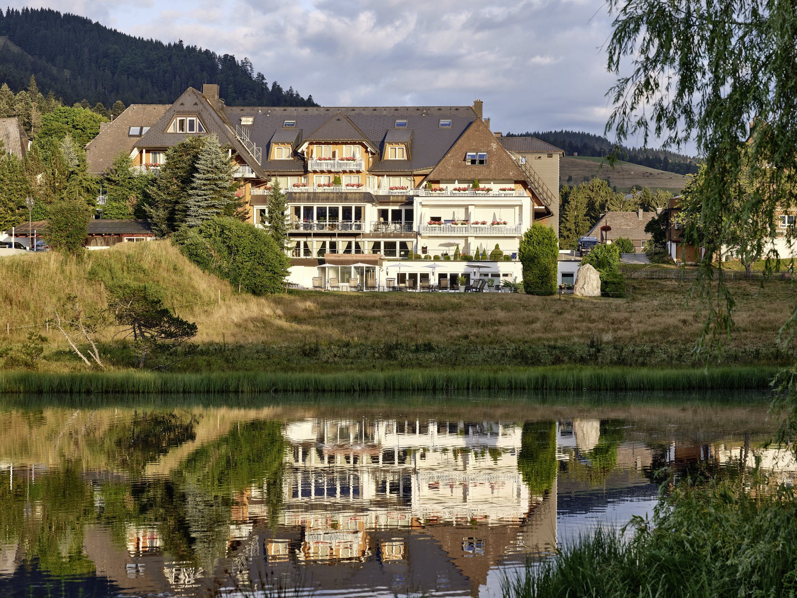 Außenansicht des Hotel Reppert mit Weiher im Vordergrund