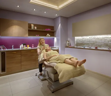 blonde Therapeutin behandelt Frau auf der Kosmetikliege im Hotel Reppert