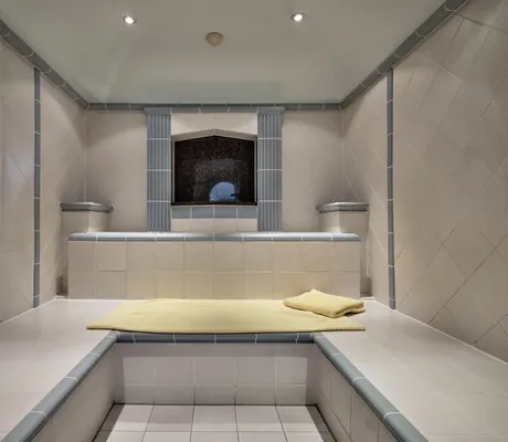 Dampfbad im Hotel Reppert mit blauen Kachelrändern und gelben Handtüchern