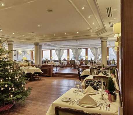 festlich eingedeckte Tische im Restaurant des Hotel Reppert mit geschmücktem Christbaum