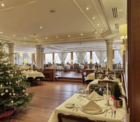 festlich eingedeckte Tische im Restaurant des Hotel Reppert mit geschmücktem Christbaum
