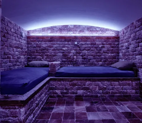 Salzlounge im Hotel Reppert mit Salz im Boden und an den Wänden und blauen Polstern
