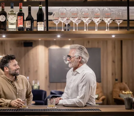 Zwei Männer an der Bar des STOCK, schauen sich an, Getränke stehen auf der Theke