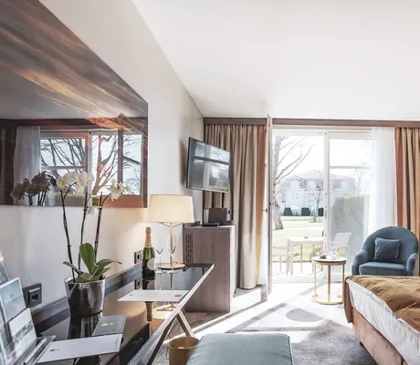 Deluxe Suite im Schloss Fleesensee mit terrakoattafarbenen Vorhängen und rostrotem Bettüberwurf