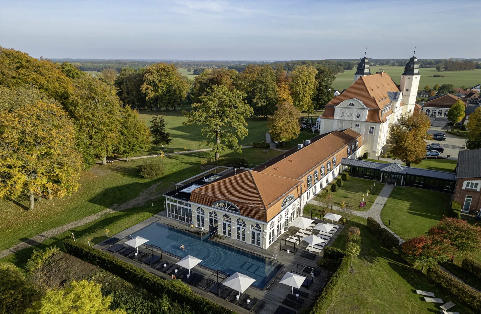 Gesamtansicht Schloss Fleesensee mit Blick auf den Außenpool und die Wiesen der Umgebung