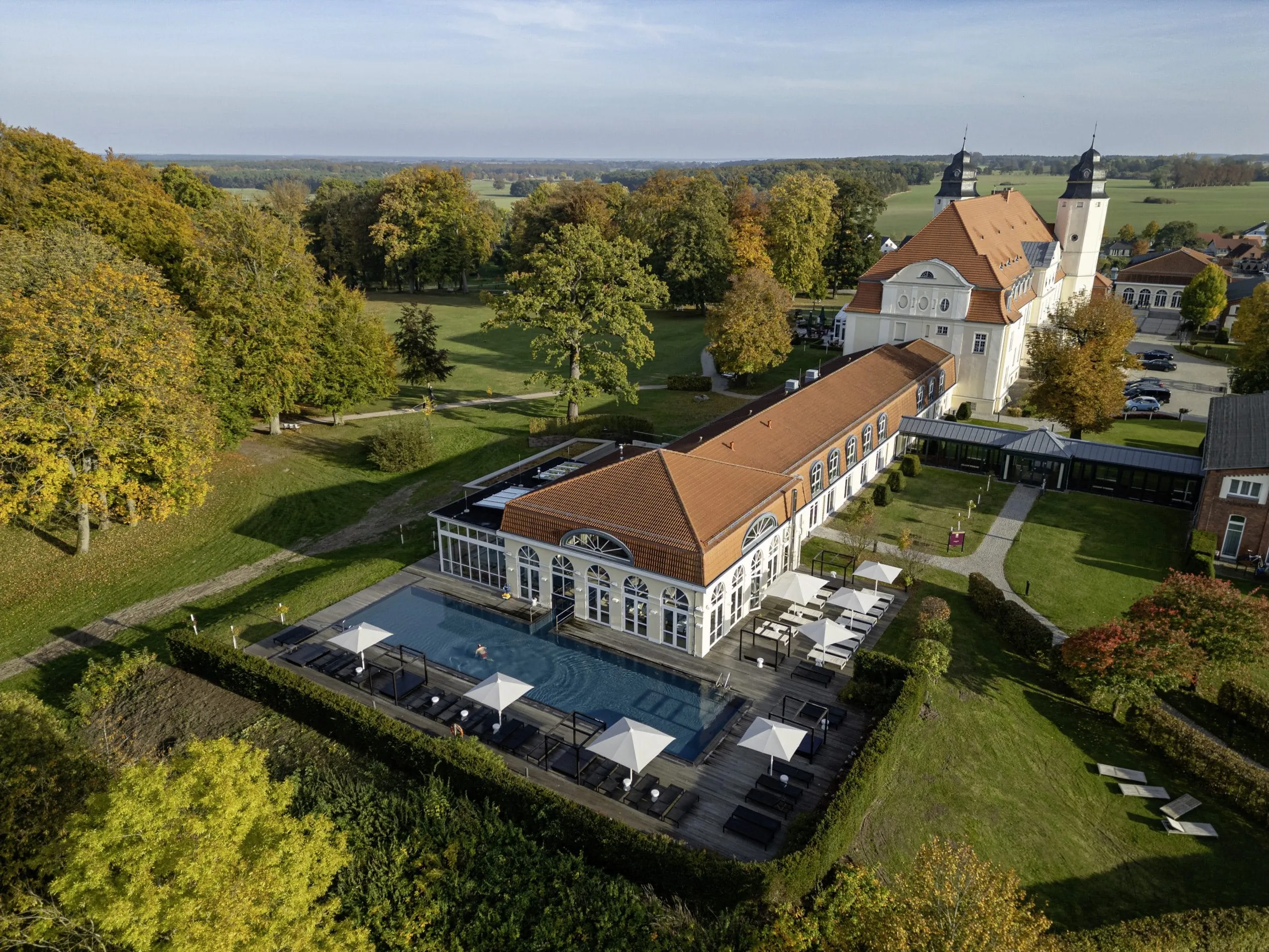 Gesamtansicht Schloss Fleesensee mit Blick auf den Außenpool und die Wiesen der Umgebung