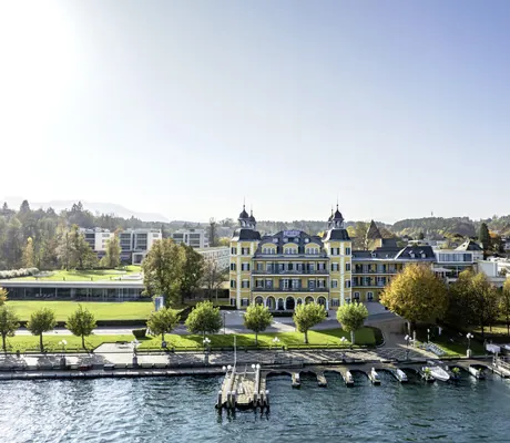 Außenansicht des Schlosshotel Velden mit Blick vom Hafen auf das Schloss und den modernen Anbau