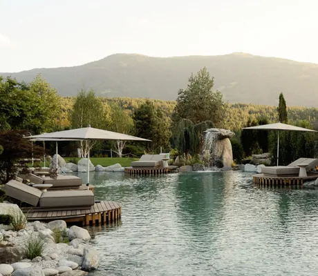 Naturbadeteich mit Steinwasserfall und Daybeds im Hotel Solvie