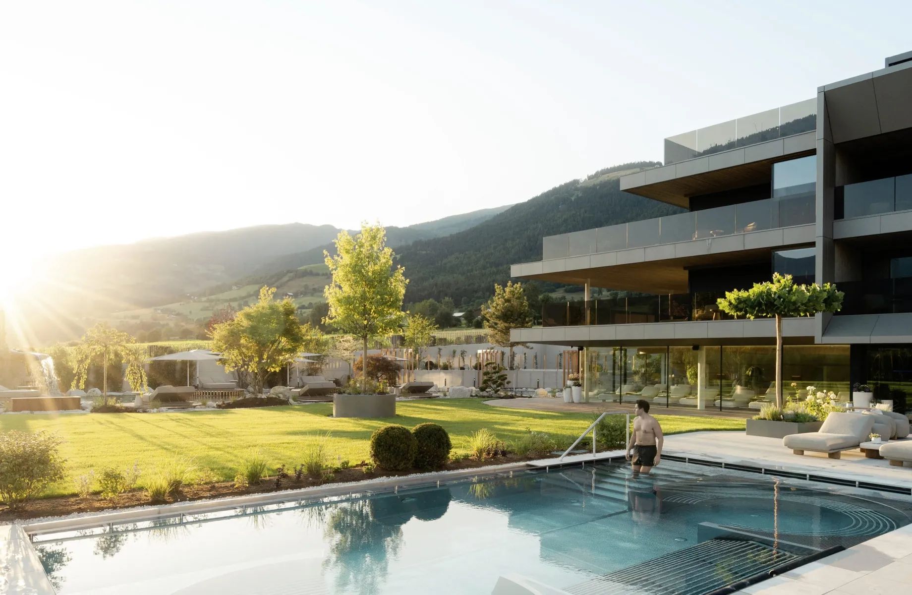 Mann geht in Outdoorpool vor der Fassade des Hotel Solvie
