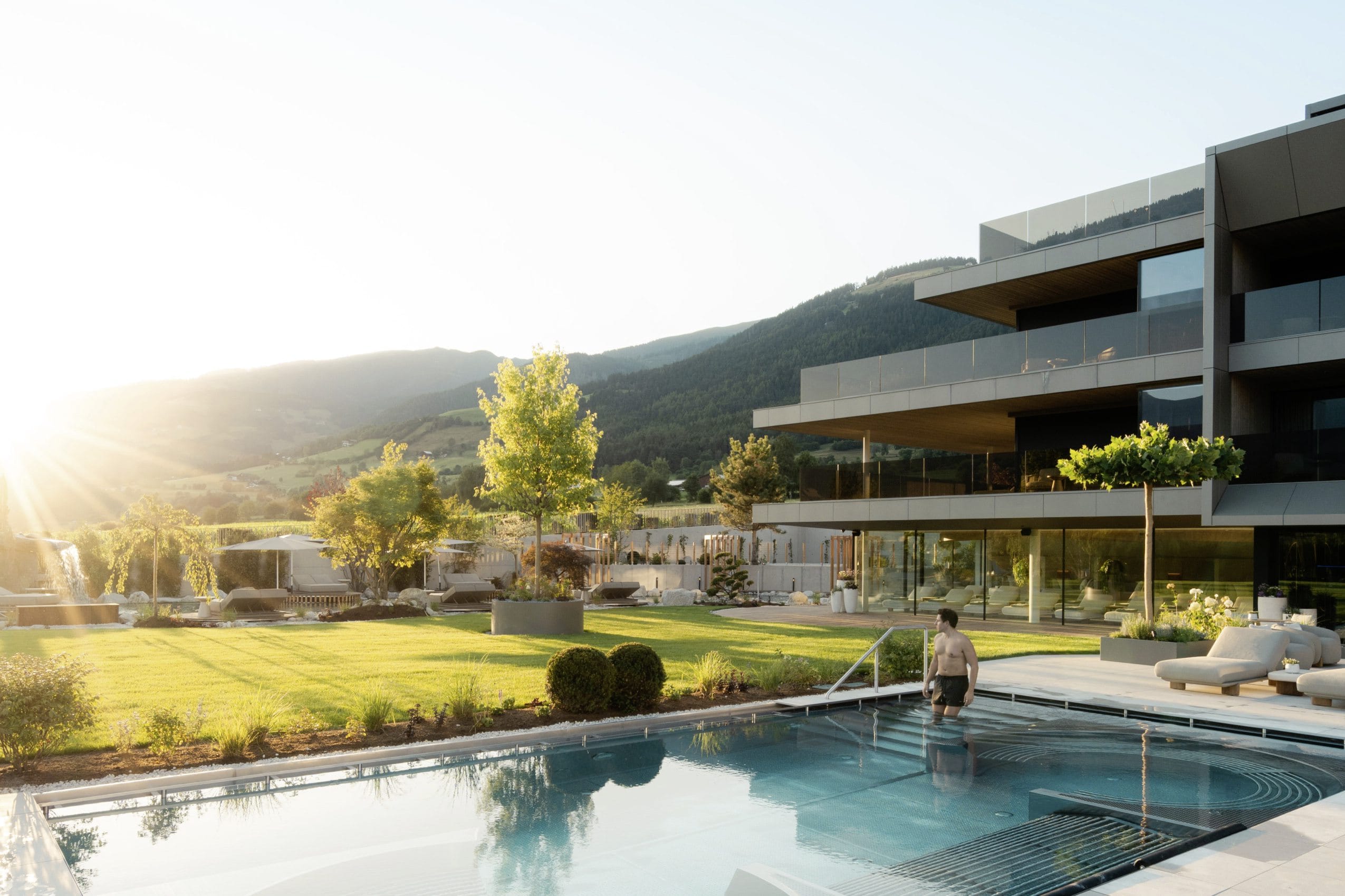 Mann geht in Outdoorpool vor der Fassade des Hotel Solvie