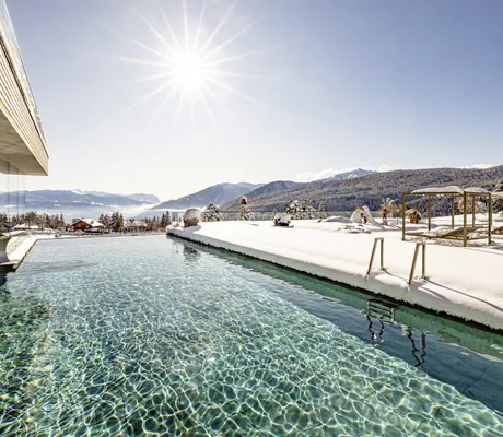 Infinitypool mit Blick in die verschneiten Berge im Sonnenberg Panorama Dolomites Wellbeing im Winter