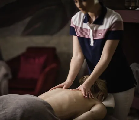 blonde Frau wird von Therapeutin im Tuxerhof massiert