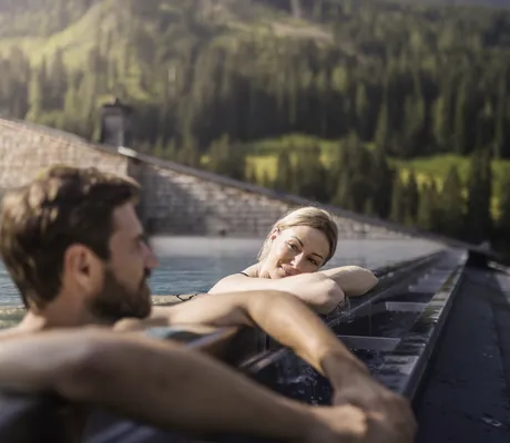 Paar liegt am Beckenrand des Skypools im Tuxerhof