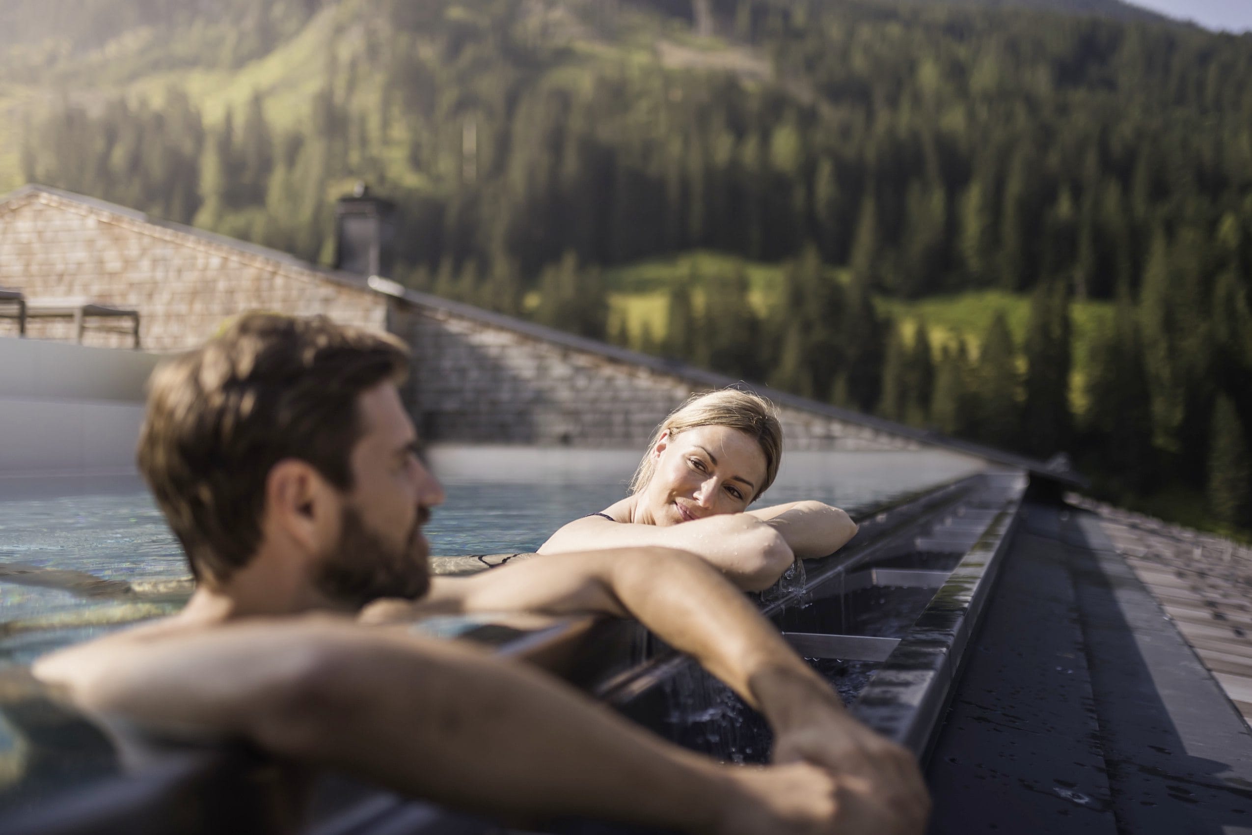 Paar liegt am Beckenrand des Skypools im Tuxerhof