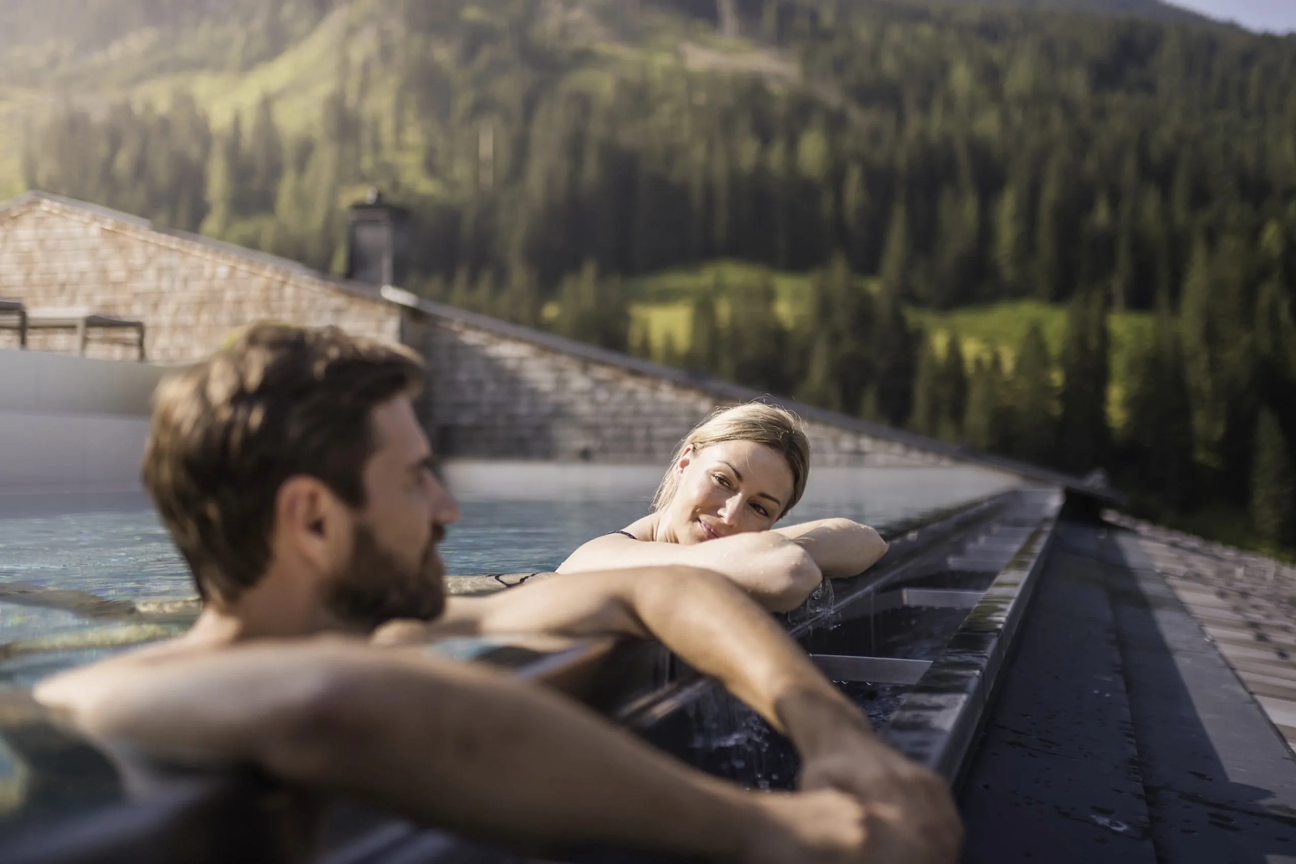 Paar liegt am Beckenrand des Skypools im Tuxerhof